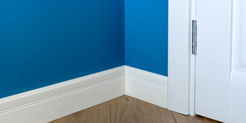 corner of room with door and baseboard trim