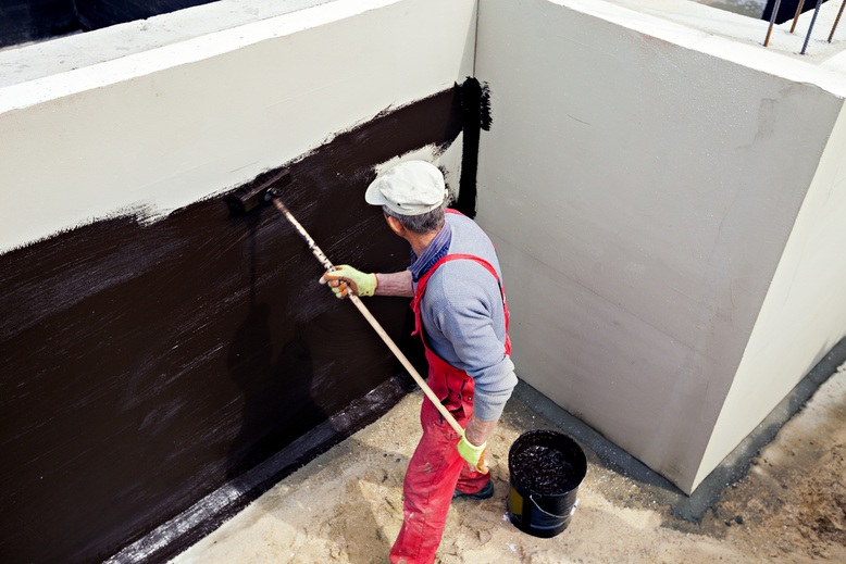 painter applying waterproof material